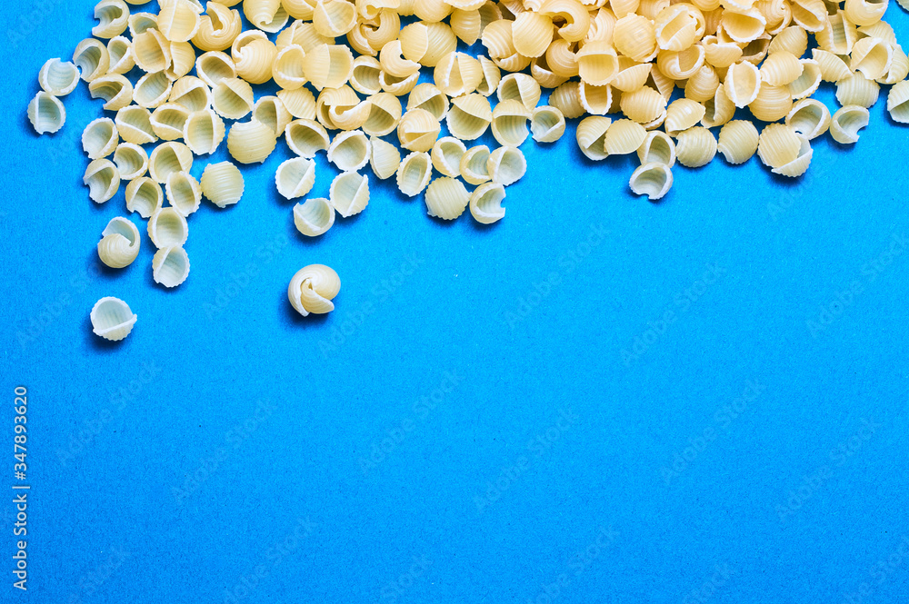 Blue background and Italian noodles, spaghetti, pasta of different forms of wheat in raw. Blue background and Italian noodles, spaghetti, pasta of different forms of wheat in raw.