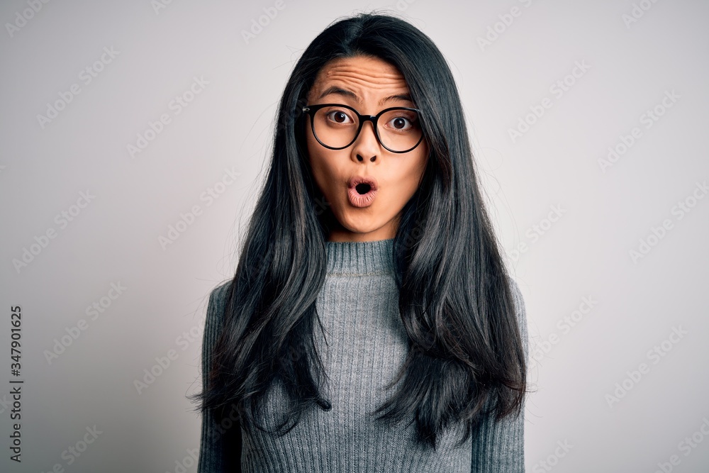 Young beautiful chinese woman wearing glasses and sweater over isolated white background afraid and shocked with surprise expression, fear and excited face. Young beautiful chinese woman wearing glasses and sweater over isolated white background afraid and shocked with surprise expression, fear and excited face.