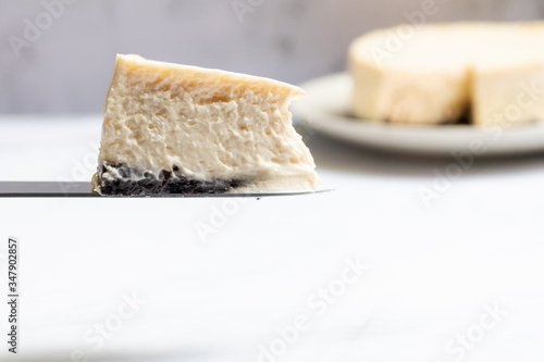Creamy cheesecake with chocolate cookies slice on knife.