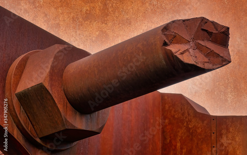 Broken off rust-coloured concrete screw on a facade