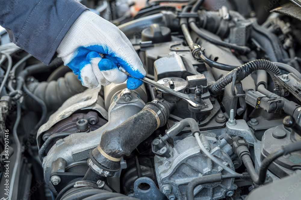 auto mechanic working with wrench key in car repairing, close-up auto mechanic working with wrench key in car repairing, close-up