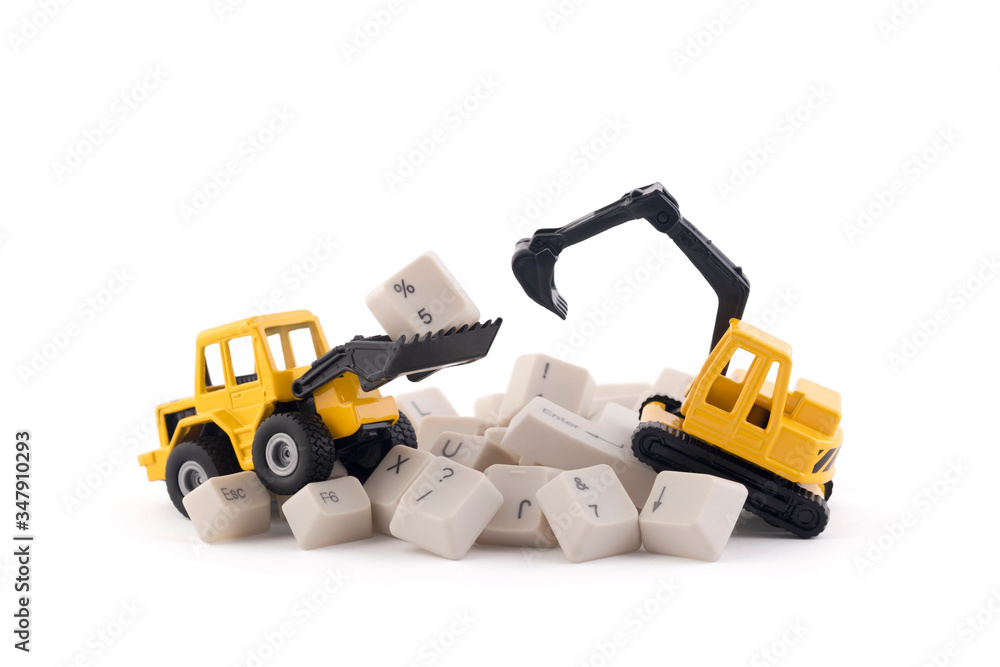 Obraz premium Bulldozer and excavator working on computer keys isolated on white background with clipping path. Website under construction concept.