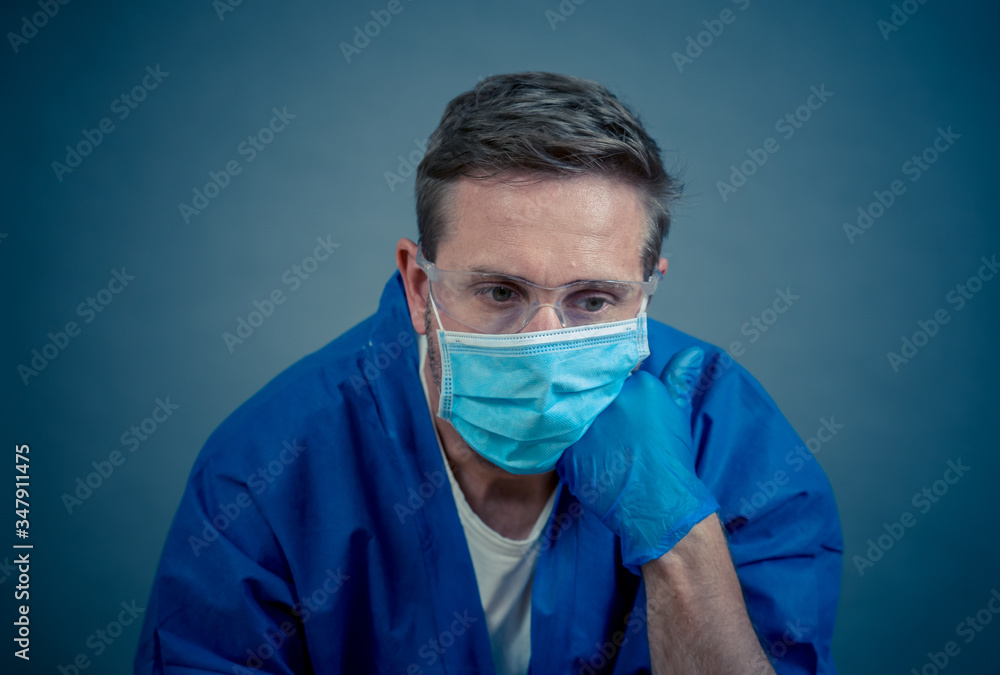 Male doctor feeling exhausted after long shift treating coronavirus infected patients at hospital Male doctor feeling exhausted after long shift treating coronavirus infected patients at hospital