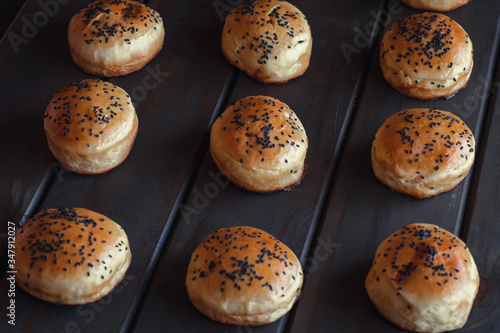 Freshly baked black sesame hamburger bun on wooden background