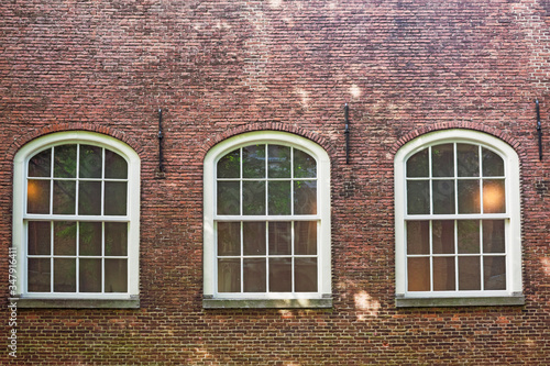 Abstract vintage city background featuring detail of medieval warehouse façade featuring gothic windows and brick wall in Delft, Netherlands. Travel or medieval background. 