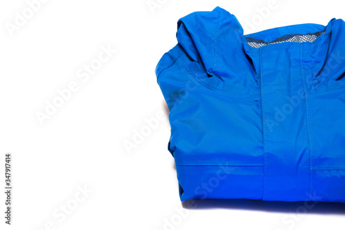 Folded blue zipper windbreaker jacket, rain proof and waterproof hiking Gore-Tex jacket hoodie. Track jacket sport nylon full zip isolated on white. Folded clothes. Outer layer garment for travel.