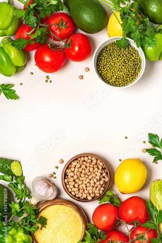 Food background. Frame of various vegetables, chickpeas, mung bean and polenta on a white background, top view. Vegetarian and vegan food, arabic cuisine. Flat lay, copy space, banner. 