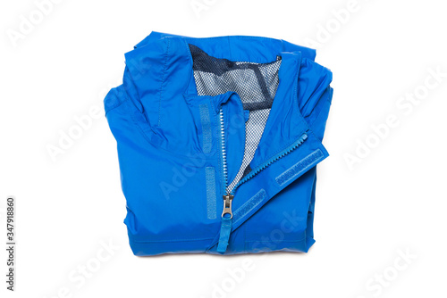 Folded blue zipper windbreaker jacket, rain proof and waterproof hiking Gore-Tex jacket hoodie. Track jacket sport nylon full zip isolated on white. Folded clothes. Outer layer garment for travel.