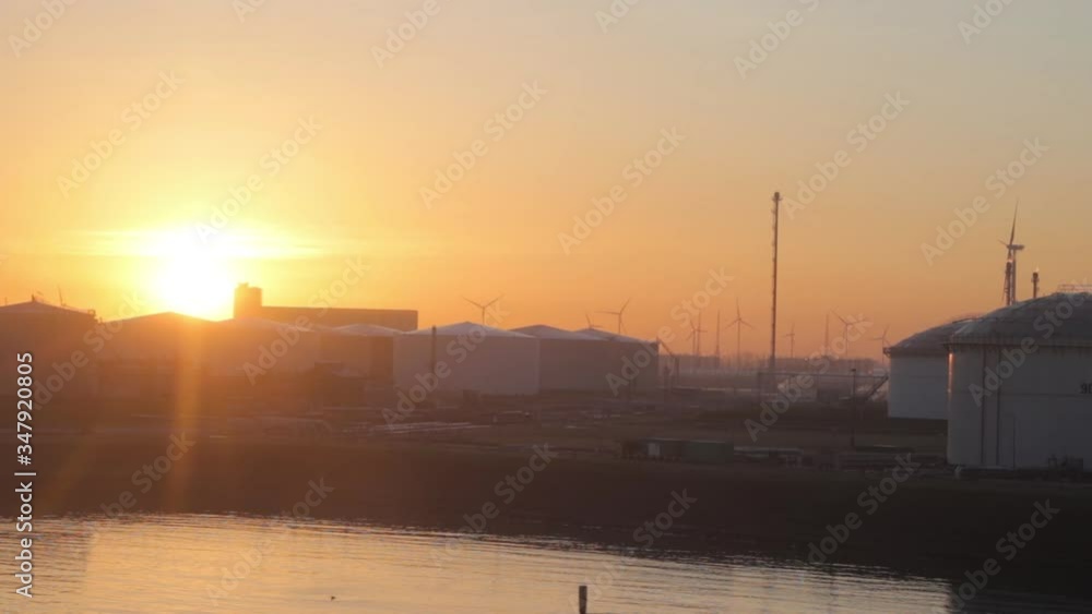 Oil storage and background with windfarms , sunrise in europeian port Oil storage and background with windfarms , sunrise in europeian port