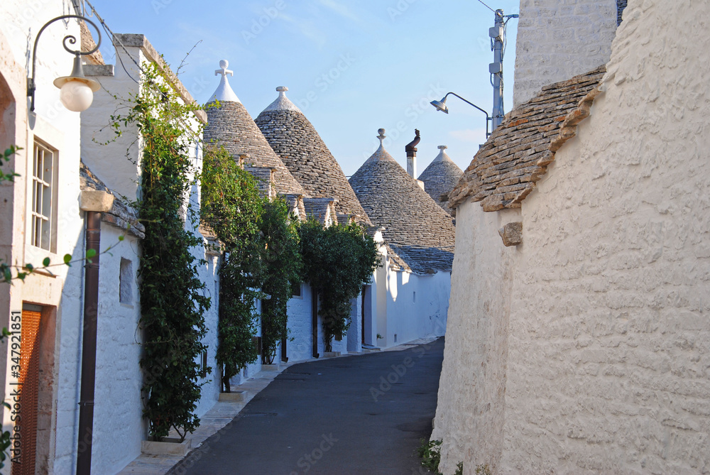 Calle de Alberobello rodeada de casas con tejados en forma de cono