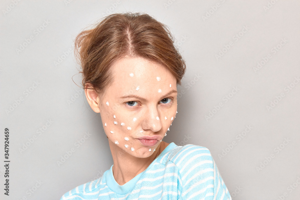 Portrait of funny flirty girl with white drops of face cream on skin Portrait of funny flirty girl with white drops of face cream on skin
