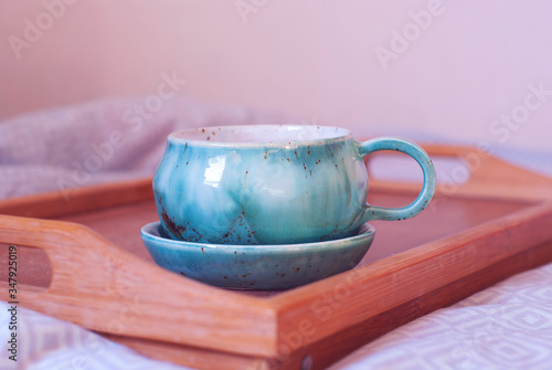 Breakfast in the bed. Big cup of tea on a tray. Comfort of home atmosphere.