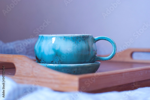 Breakfast in the bed. Big cup of tea on a tray. Comfort of home atmosphere.