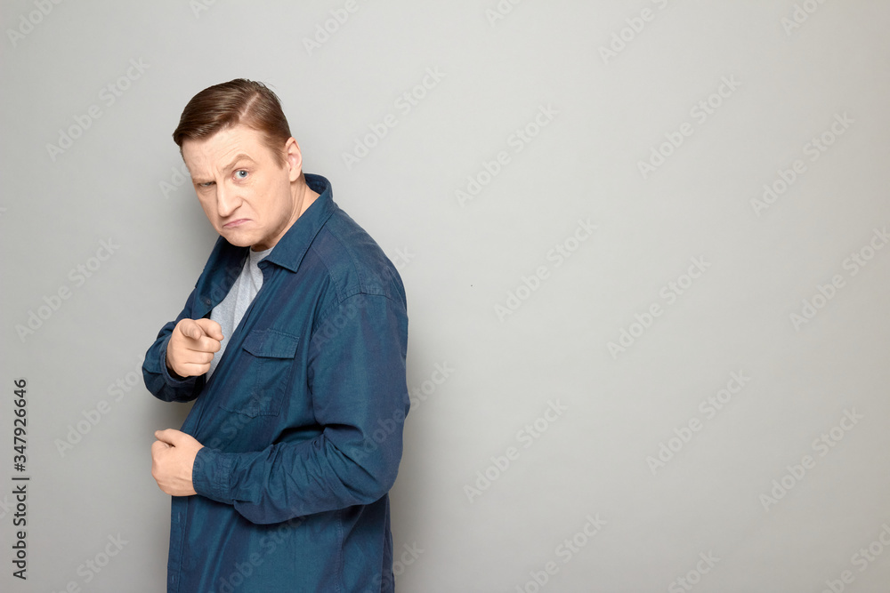 Portrait of angry mature man pointing with index finger at you Portrait of angry mature man pointing with index finger at you
