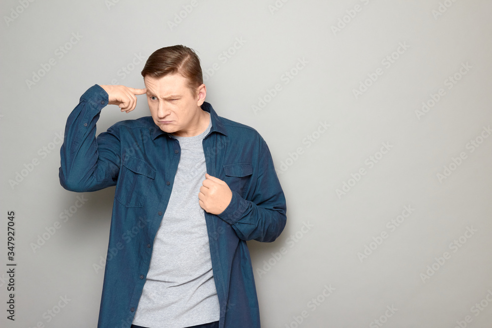 Portrait of funny thoughtful man touching head with finger and thinking hard Portrait of funny thoughtful man touching head with finger and thinking hard