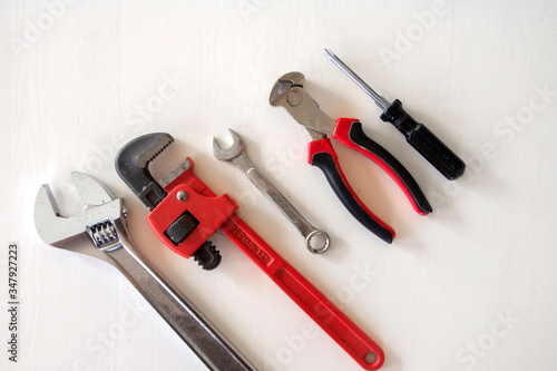 Male tools. Happy Father's Day inscription with screwdriver, Mechanic hand hold spanner tool, pliers on white background. Greetings and presents. , copyspace, 
