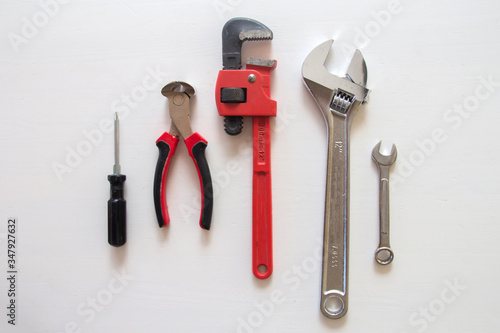 Male tools. Happy Father's Day inscription with screwdriver, Mechanic hand hold spanner tool, pliers on white background. and presents. white card with the ability to insert text, copyspace,  