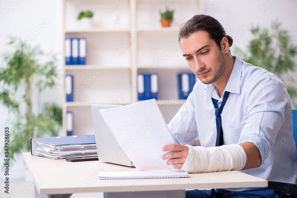 Injured male employee at workplace after accident Injured male employee at workplace after accident