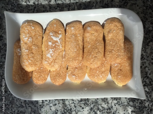 Closeup photo of tasty wholesome light cookie home baking savoyardi on a dish  photo
