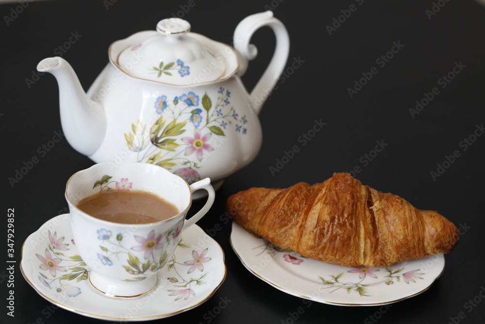 Continental breakfast with a teapot on a black table Continental breakfast with a teapot on a black table