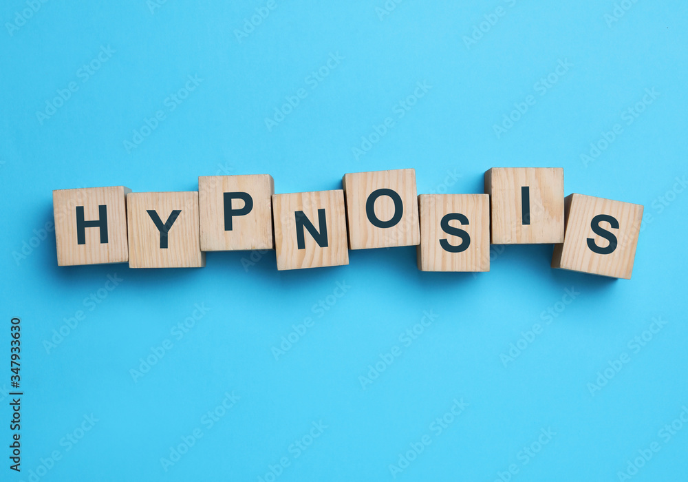 Wooden blocks with word HYPNOSIS on light blue background, flat lay Wooden blocks with word HYPNOSIS on light blue background, flat lay