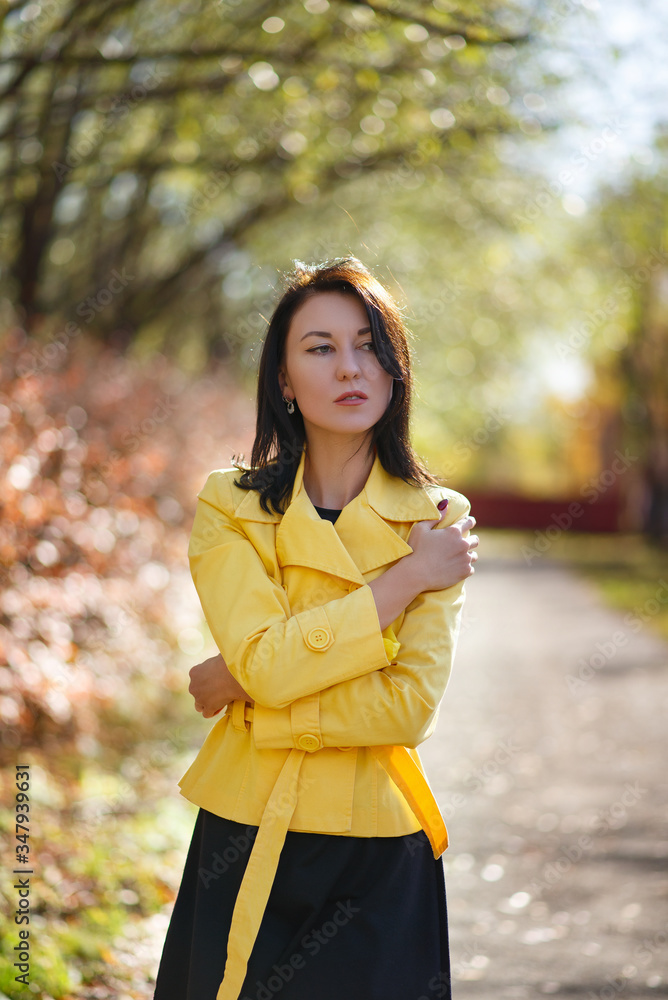 young brunette in a yellow jacket in a Park. young brunette in a yellow jacket in a Park.