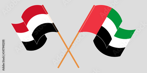 Crossed and waving flags of Yemen and the United Arab Emirates