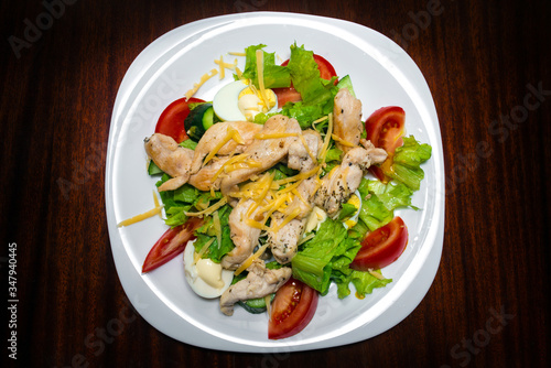 Salad with chicken and vegetables in a white plate