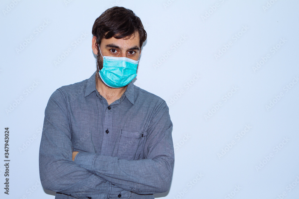 portrait of man with beard and casual clothes and surgical mask on white background. social distancing portrait of man with beard and casual clothes and surgical mask on white background. social distancing