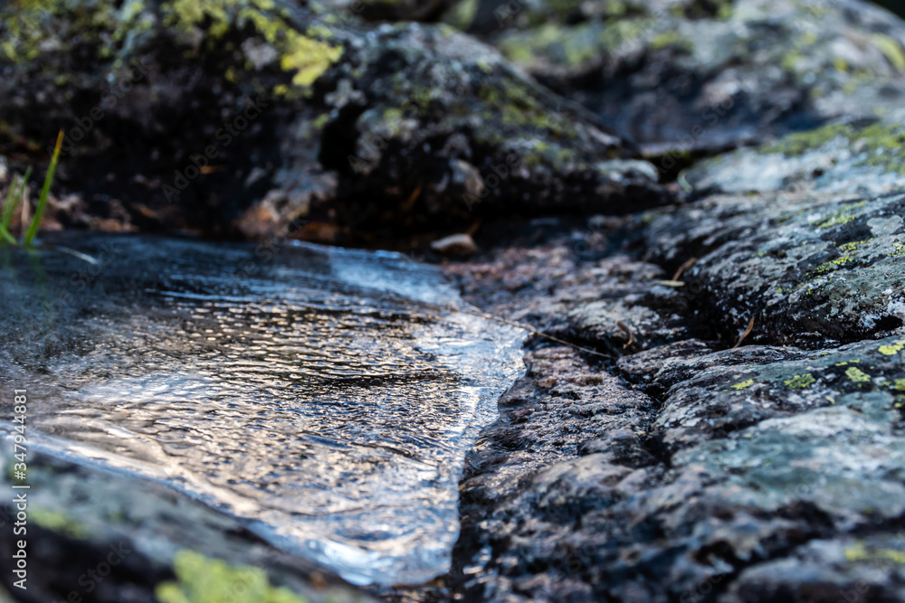 A picturesque close-up view of a frozen puddle on a rock in the Pyrenees mountains on a winter day (Arrens-Marsous, Hautes-Pyrenees, France) A picturesque close-up view of a frozen puddle on a rock in the Pyrenees mountains on a winter day (Arrens-Marsous, Hautes-Pyrenees, France)
