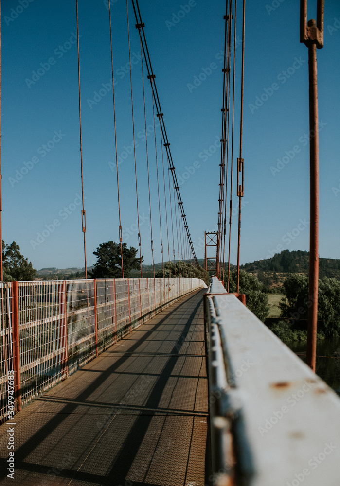 puente colgante sobre un rio con vistas hacia la montaña puente colgante sobre un rio con vistas hacia la montaña