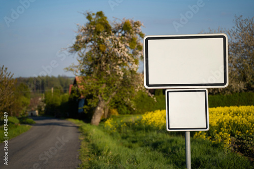 City name sign. Empty enameled clear plate road sign before nice small village and romantic Czech nature along the road. Signage board