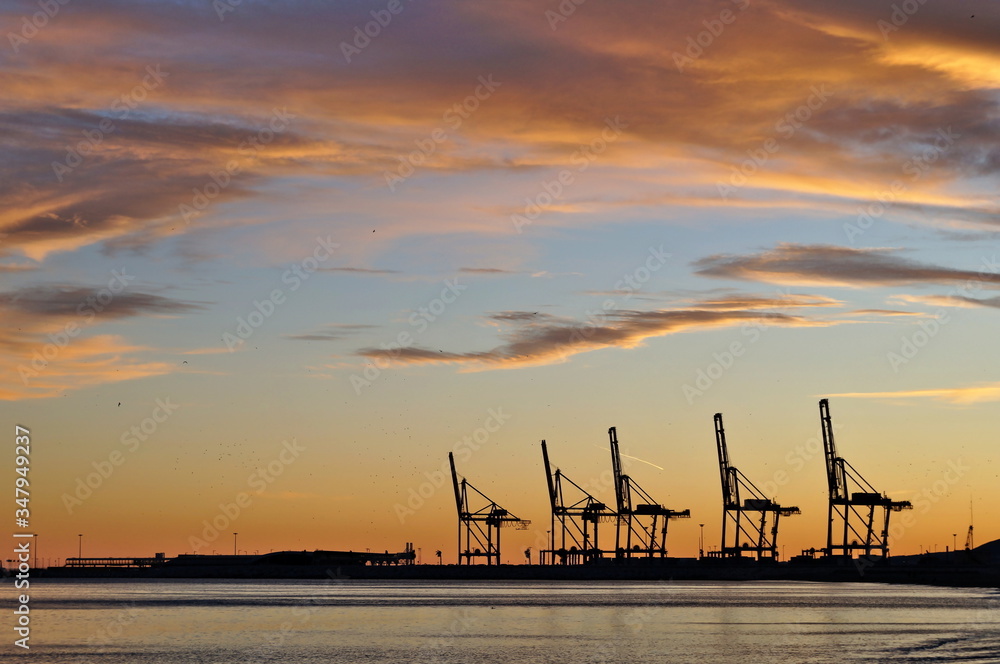 cranes of Málaga port against a dramatic evening sky cranes of Málaga port against a dramatic evening sky