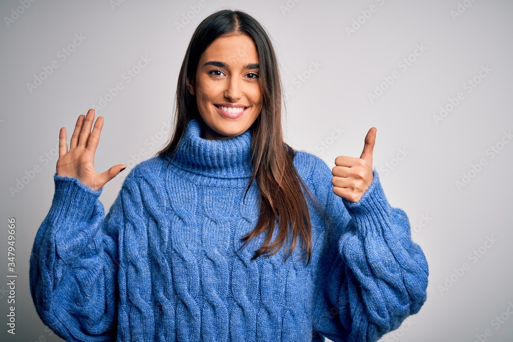 Young beautiful brunette woman wearing casual turtleneck sweater over white background showing and pointing up with fingers number six while smiling confident and happy. Young beautiful brunette woman wearing casual turtleneck sweater over white background showing and pointing up with fingers number six while smiling confident and happy.