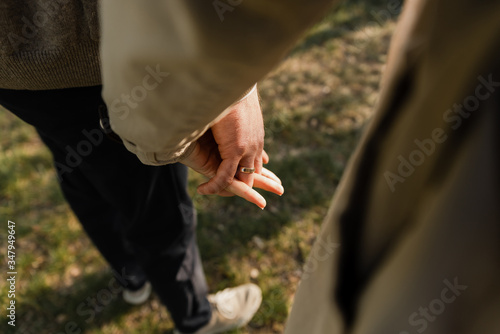 happy young pregnant couple walks in the park,husband holds the hand of his pregnant wife,future dad and mom,walks in the park after quarantine © Vadym