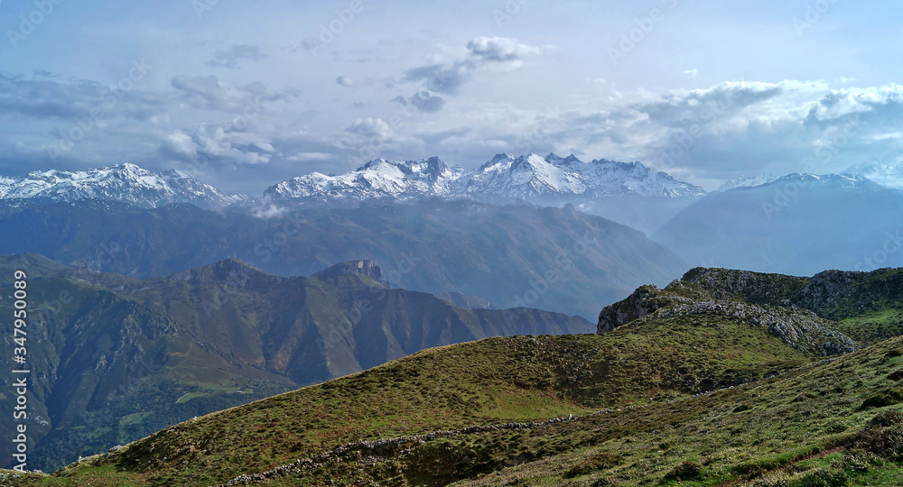 panoramic view from Sierra del Cuera mountains towards Picos de Europa in Asturias with dramatic cloud sky panoramic view from Sierra del Cuera mountains towards Picos de Europa in Asturias with dramatic cloud sky