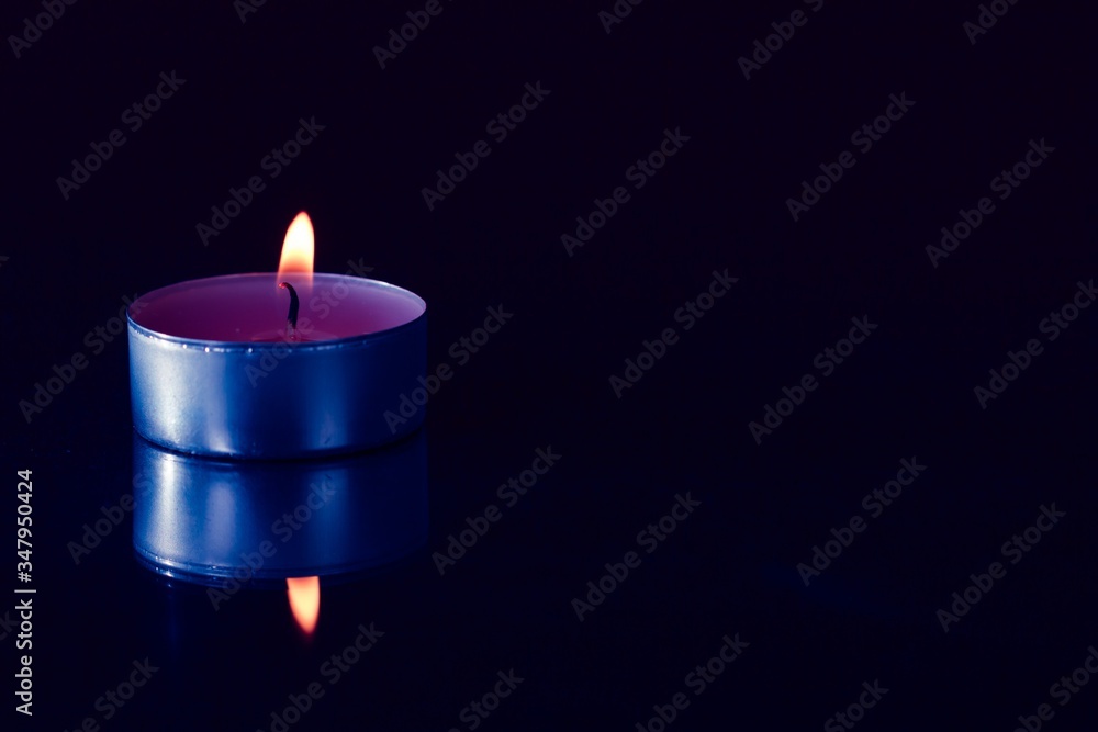 burning candle on a black background burning candle on a black background