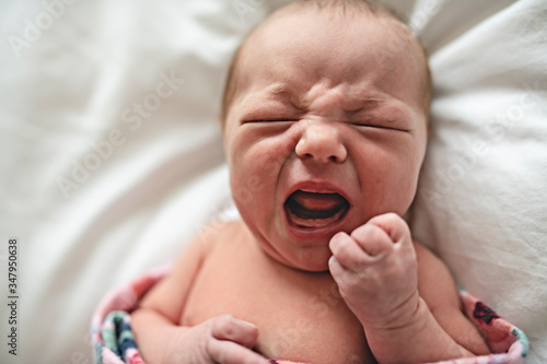 Canvas Print A cute Newborn baby crying in bed