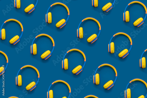 Pattern of multi-colored headphones on blue background. Minimalistic fashion music concept. Trendy color of the year concept. Top view, flat lay