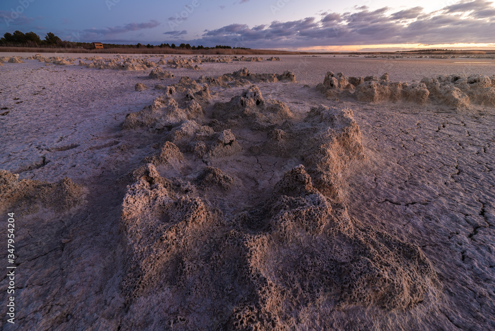 From above of drought cracked lifeless ground under colorful cloudy sky at sunset time From above of drought cracked lifeless ground under colorful cloudy sky at sunset time