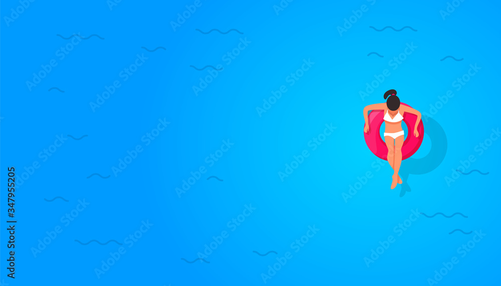 Minimal composition of girl in a swimming circle at sea with copyspace on blue background, top view, flat lay