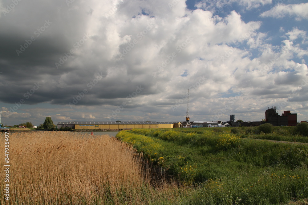 Dark storm clouds over the Hollandsche IJssel river near Oudekerk aan den IJssel near wood trade Heuvelman Dark storm clouds over the Hollandsche IJssel river near Oudekerk aan den IJssel near wood trade Heuvelman