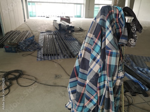 Plaid shirt of the mechanic worker laying on the construction site