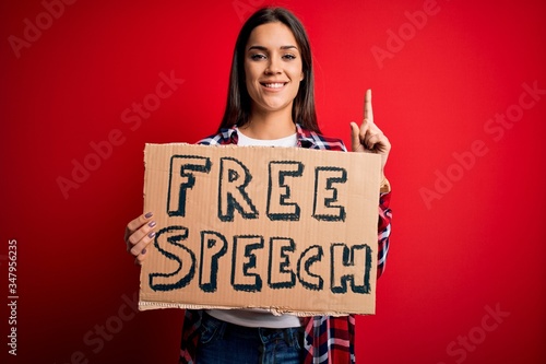 Wallpaper Mural Young beautiful brunette woman asking for rights holding banner with free speech message surprised with an idea or question pointing finger with happy face, number one Torontodigital.ca