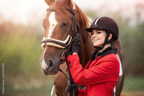 Equestrian sport Woman jockey holding horse by bridle outdoors