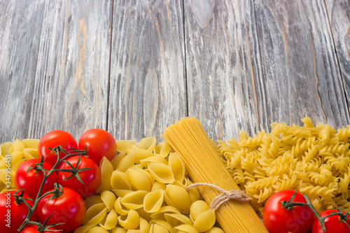 Set various raw ingredients for cooking Italian pasta on gray table, top view