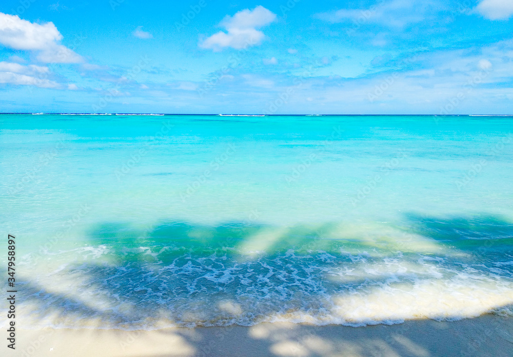 Beautiful beach with white sand, turquoise ocean water and blue sky with clouds in sunny day