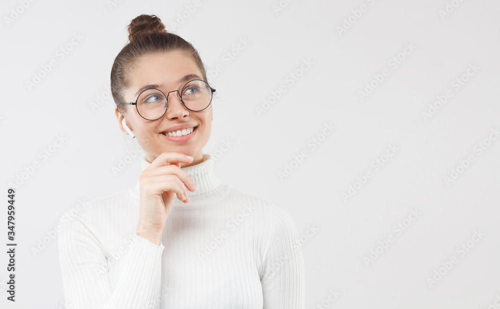 Horizontal banner of young woman holding chin, dreaming about pleasant future plans, smiling happily, isolated on gray background with copy space on right Horizontal banner of young woman holding chin, dreaming about pleasant future plans, smiling happily, isolated on gray background with copy space on right