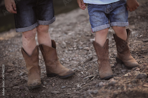 Two little boys in cowboy boots close up