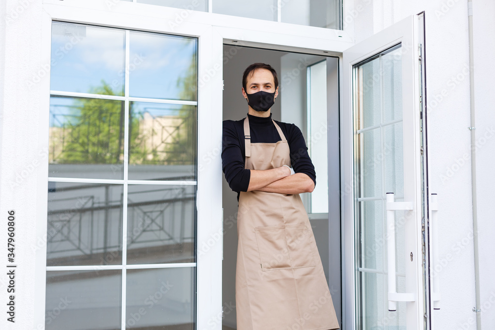 male cafe owner in apron and protective mask